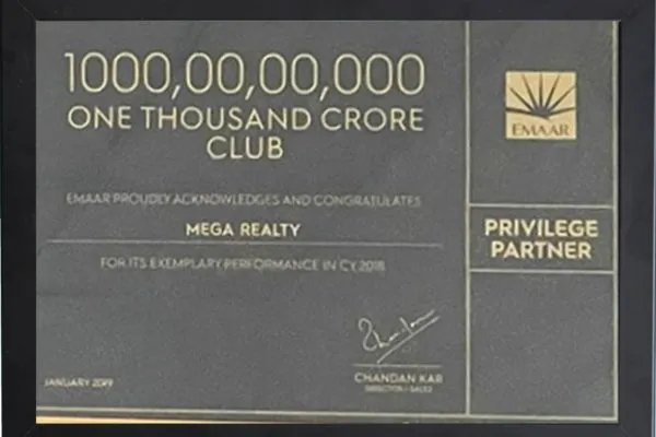 A dark grey framed plaque from Emaar India recognizing Mega Realty as a member of the "One Thousand Crore Club (₹1000,00,00,000)" and as a Privilege Partner for exemplary performance in CY 2018. Signed by Chandan Kar, Director – Sales, dated January 2019.